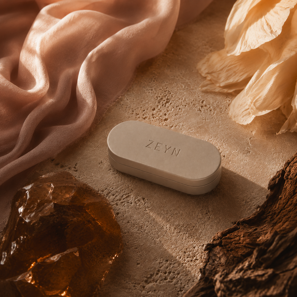 ZEYN warm stone refillable fragrance case styled with silk, amber resin, florals, and wood notes to evoke shifting scent moods
