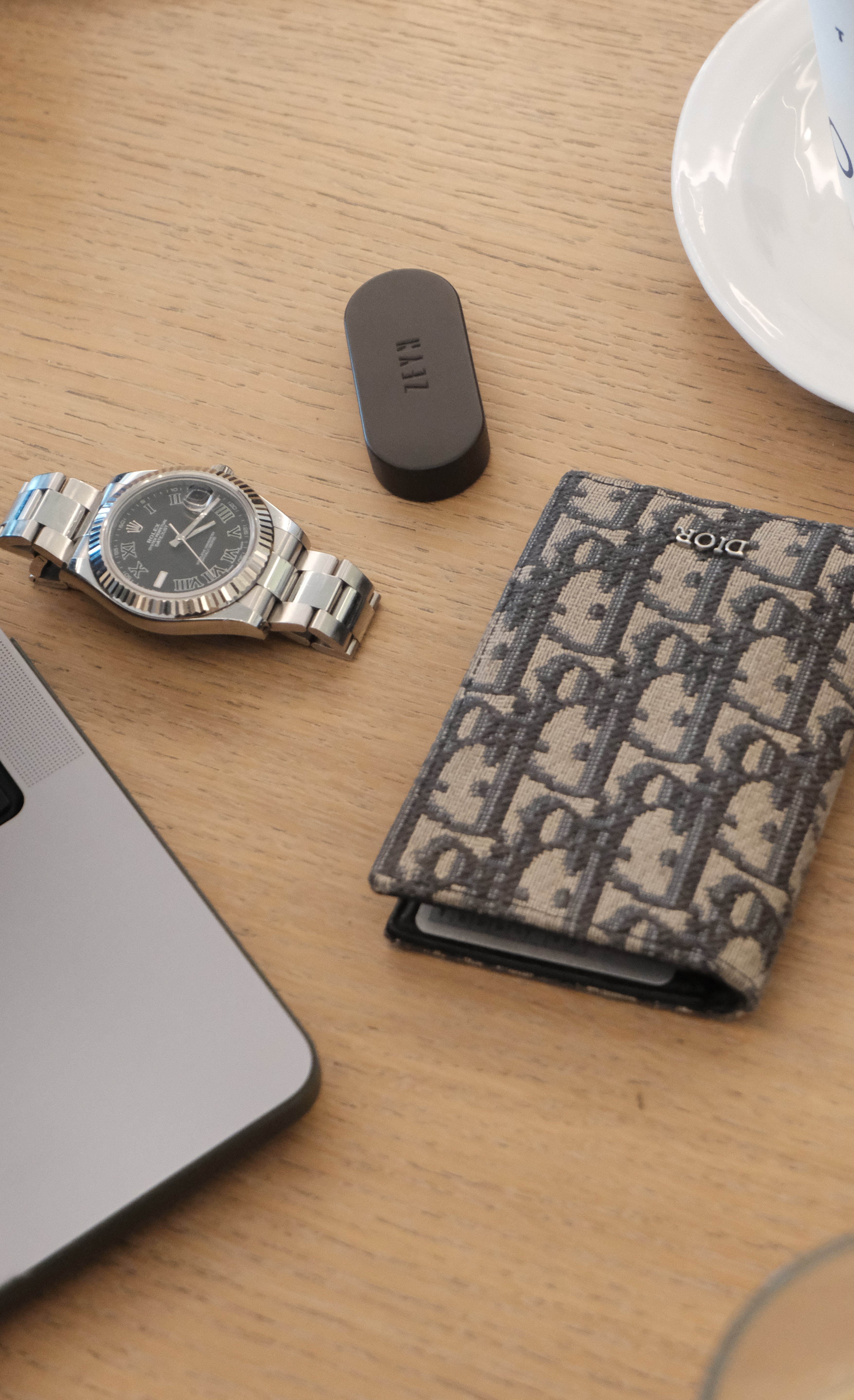 Watch, wallet, and ZEYN device on a wooden surface
